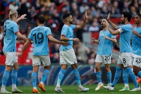 Riyad Mahrez of Manchester City is congratulated by his teammates after he scores the opening goal from the penalty spot.