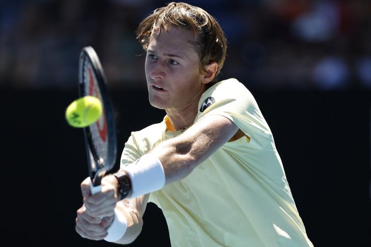 An American male tennis player hits a backhand at the Australian Open.