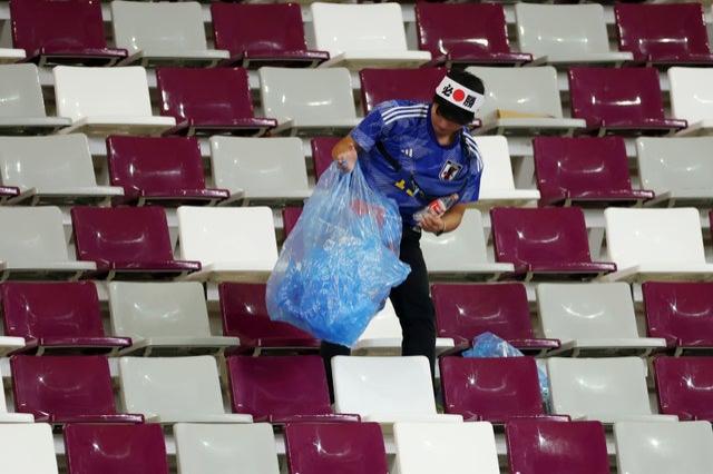 A Japanese fan clears rubbish from the stands 