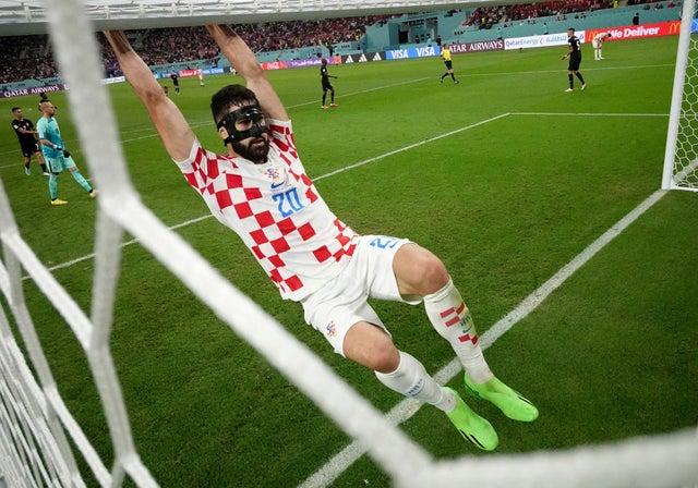 Croatia’s Josko Gvardiol hangs off the crossbar